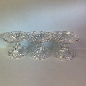 Set of three clear crystal candleholders.